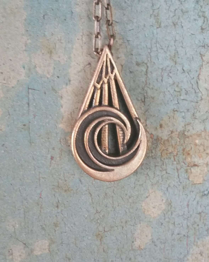 Handcrafted solid bronze mountain wave necklace on an 18 or 24 inch antique bronze chain. Made in USA with a lifetime warranty.