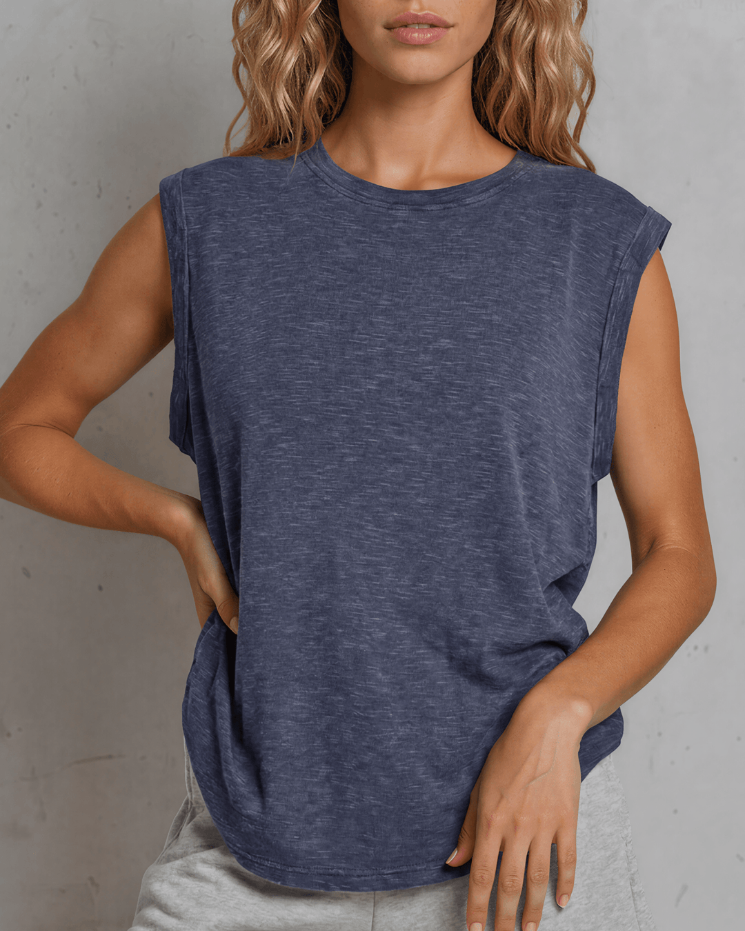Effortlessly chic and undeniably comfortable, this made in USA women's cotton muscle tee delivers laid-back style with everyday versatility. Crafted from a breathable 75% cotton and 25% polyester blend, it features a classic round neckline and signature rolled muscle sleeves that frame the shoulders beautifully. 