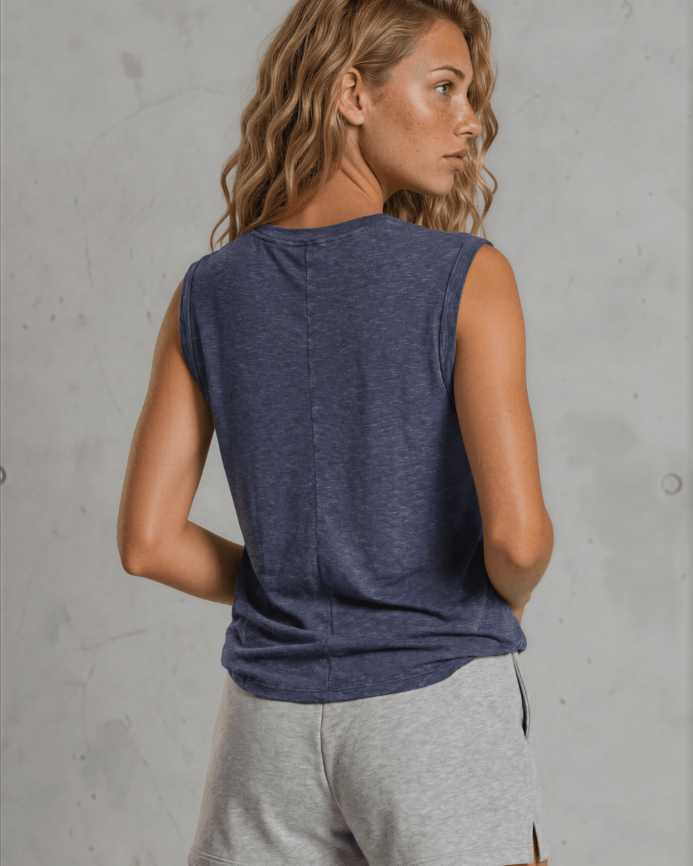 Effortlessly chic and undeniably comfortable, this made in USA women's cotton muscle tee delivers laid-back style with everyday versatility. Crafted from a breathable 75% cotton and 25% polyester blend, it features a classic round neckline and signature rolled muscle sleeves that frame the shoulders beautifully. 