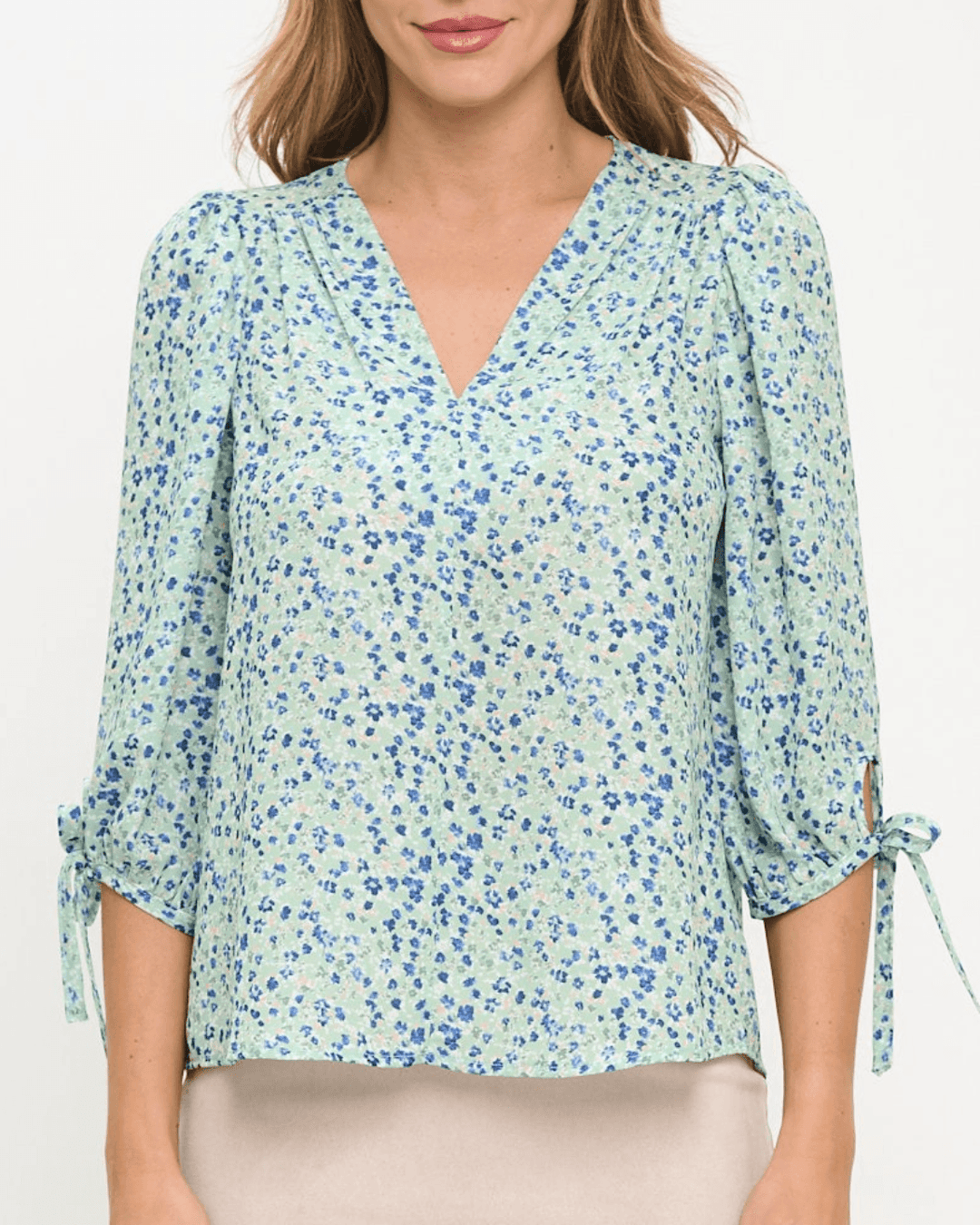Delilah Ditsy Floral Top in Sage. V-neck, 3/4 tie sleeves, relaxed fit, 100% polyester. Feminine floral blouse made in the USA. Sizes S–L.