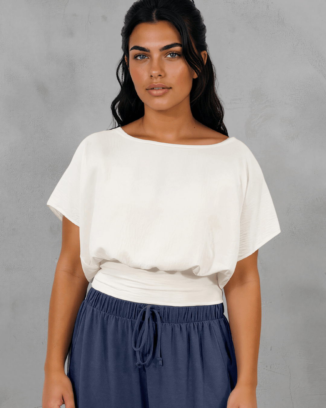 Shop the Sandra Flowy Short Sleeve Top with Smocked Waist in White. Blousy crop top, fitted smocked waist, 100% polyester. Made in USA. Sizes S–L.