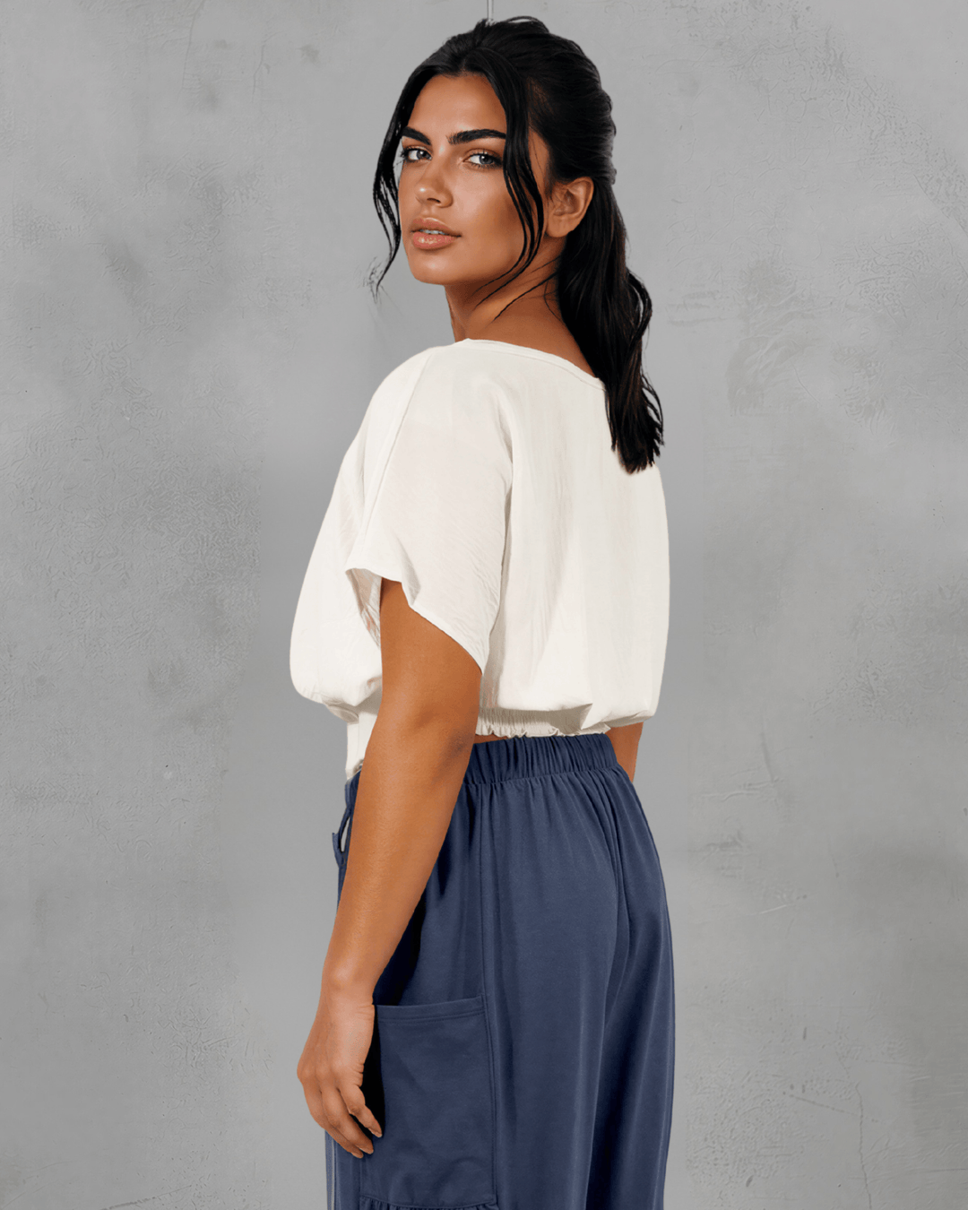 Shop the Sandra Flowy Short Sleeve Top with Smocked Waist in White. Blousy crop top, fitted smocked waist, 100% polyester. Made in USA. Sizes S–L.