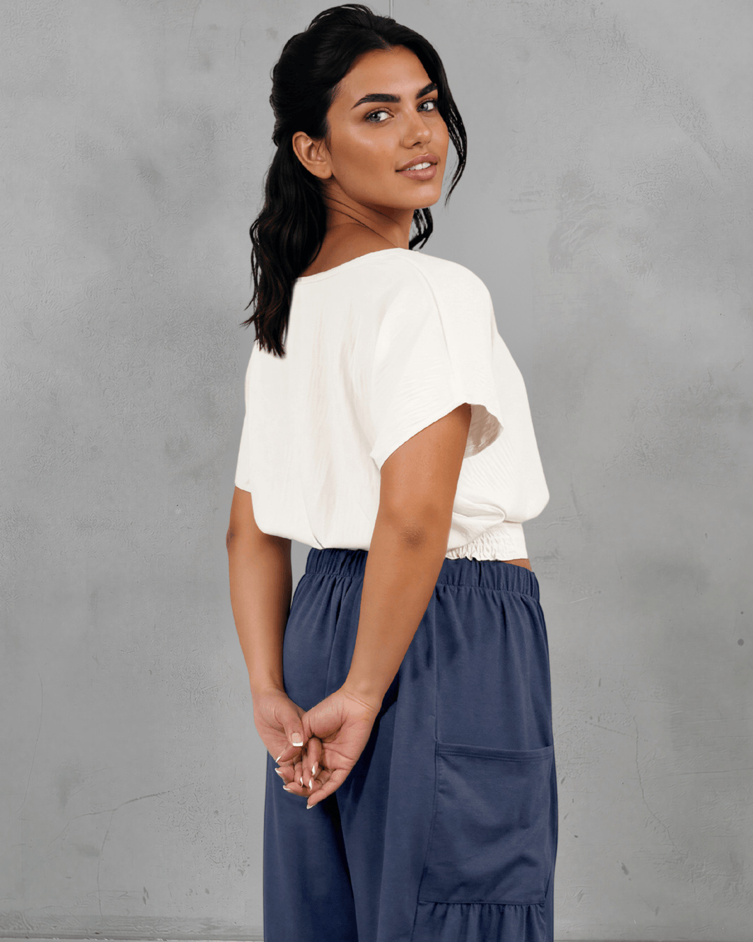 Shop the Sandra Flowy Short Sleeve Top with Smocked Waist in White. Blousy crop top, fitted smocked waist, 100% polyester. Made in USA. Sizes S–L.