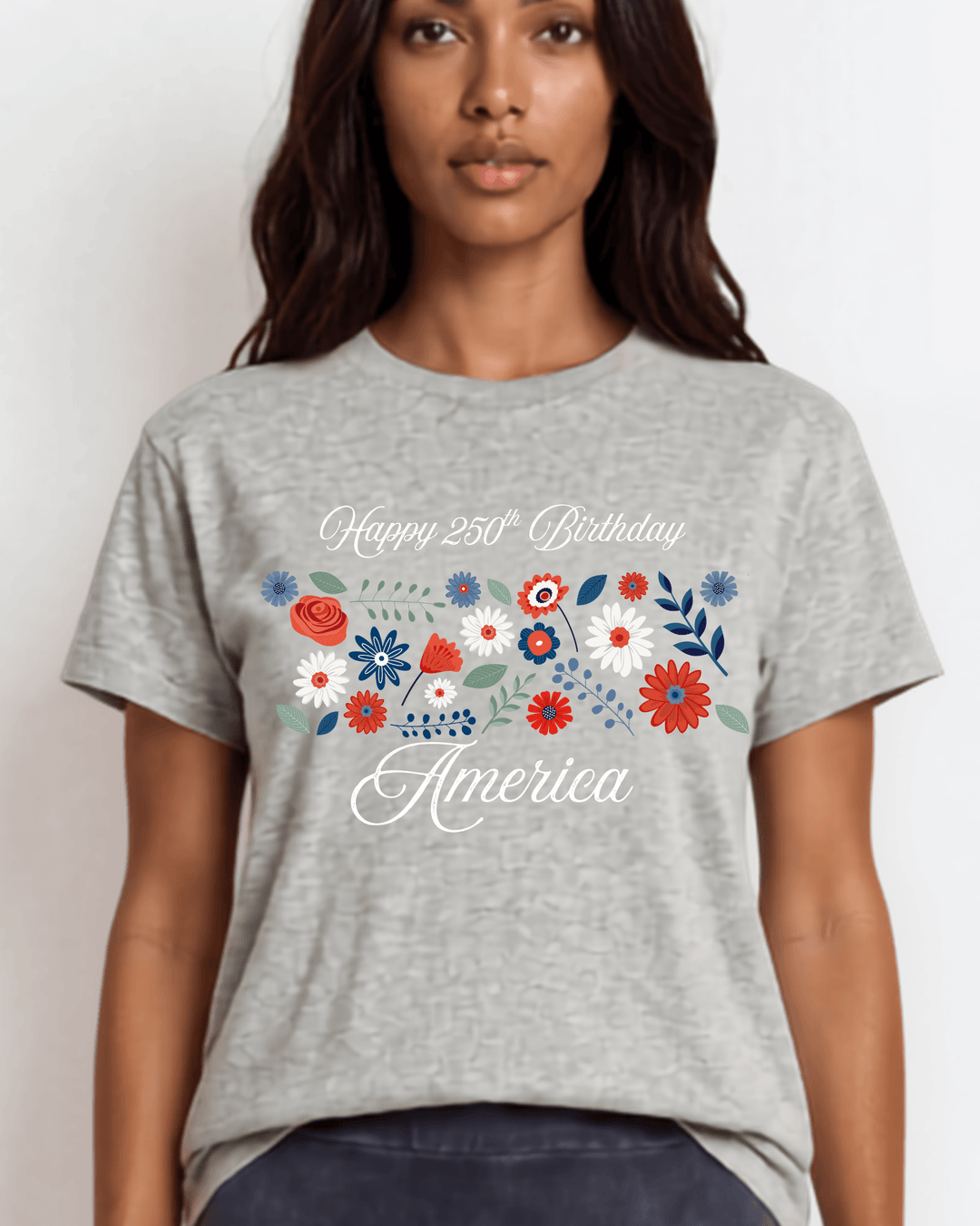 "Happy 250th Birthday America" floral graphic tee — red, white & blue wildflowers on heather gray. Made in USA, 100% cotton, relaxed fit, XS–3X. Perfect for 4th of July.