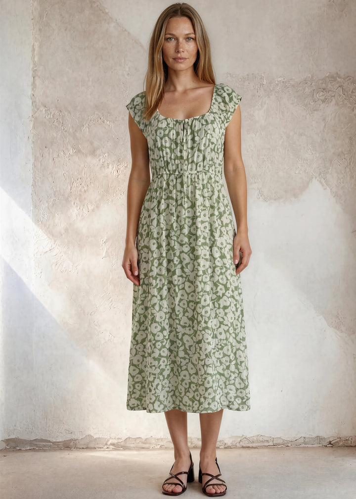 Lightweight sage green floral midi dress with a square neckline, tie front detail, ruffled cap sleeves, and smocked waist. Made in USA. Available in sizes S-XL.