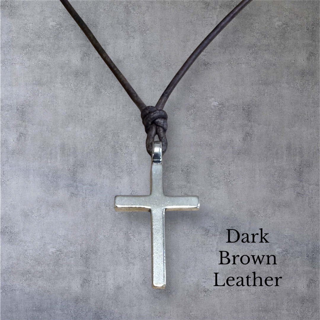Handcrafted solid sterling silver cross on an adjustable leather cord. Unisex. Available in black, dark brown, or red brown. Made in USA