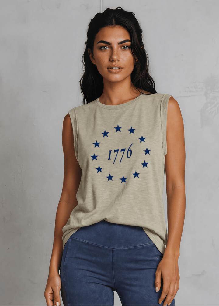 1776 Betsy Ross 13 Stars Graphic Muscle Tee — Made in USA. Light olive, relaxed fit, 75% cotton. Sleeveless patriotic top perfect for 4th of July. Sizes S-L.