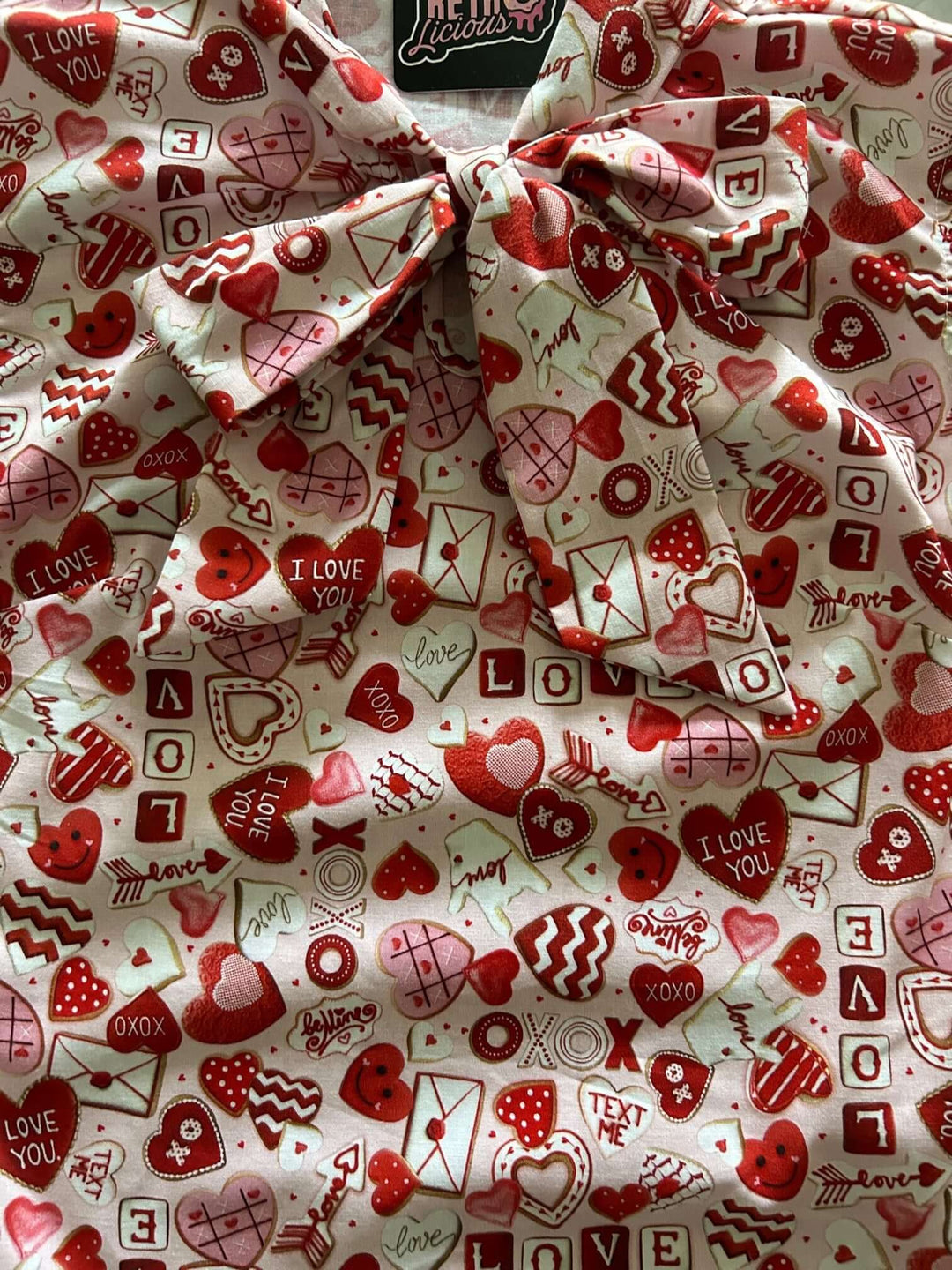 Vintage Tops This top is for the vintage lover at heart! Shown in our XOXO print, this 100% cotton top features bust darts for a flattering silhouette, a side zippered closure for ease of wear, and an oversized bow at the neckline for that perfect 1950&
