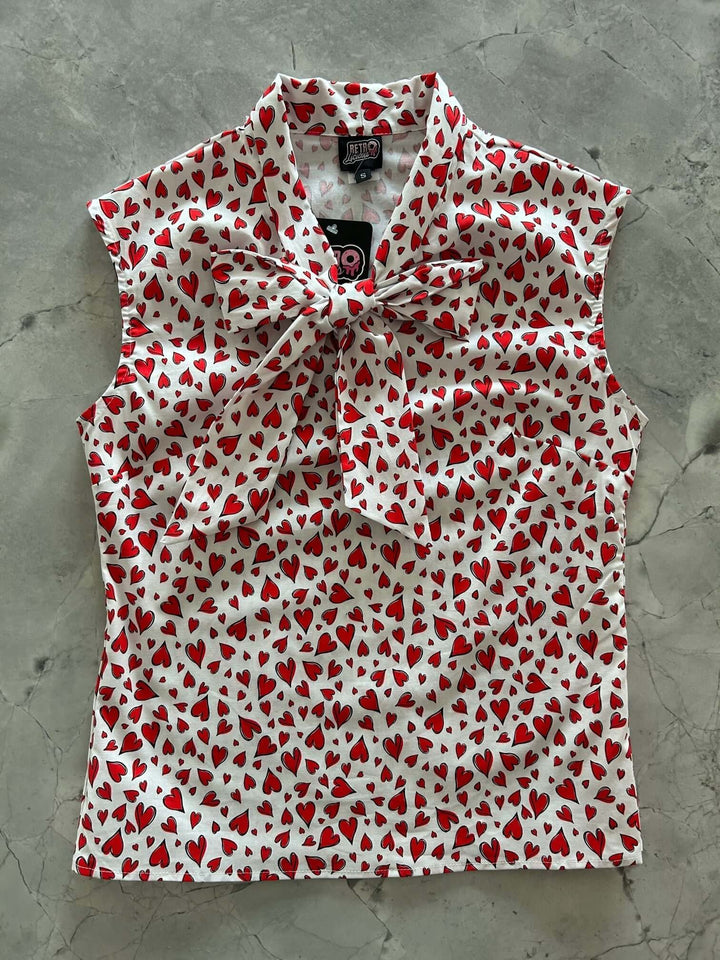 Vintage Style Tops This top is for the vintage lover at heart! Shown in our hearts print, this 100% cotton top features bust darts for a flattering silhouette, a side zippered closure for ease of wear, and an oversized bow at the neckline for that perfect 1950&