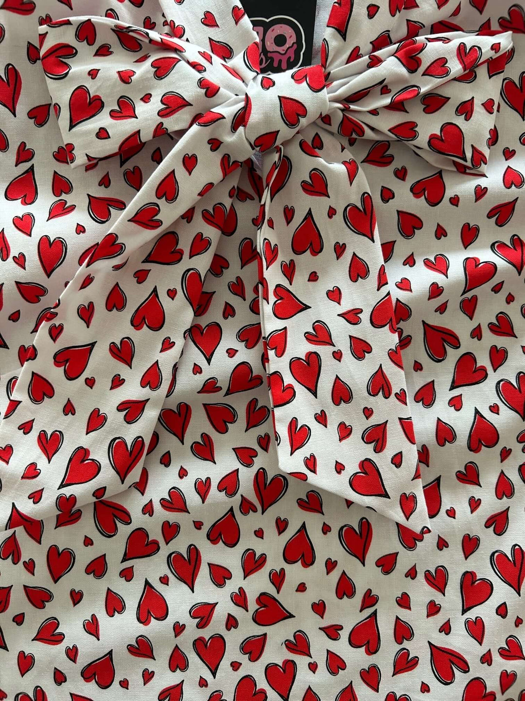 Vintage Style Tops This top is for the vintage lover at heart! Shown in our hearts print, this 100% cotton top features bust darts for a flattering silhouette, a side zippered closure for ease of wear, and an oversized bow at the neckline for that perfect 1950&