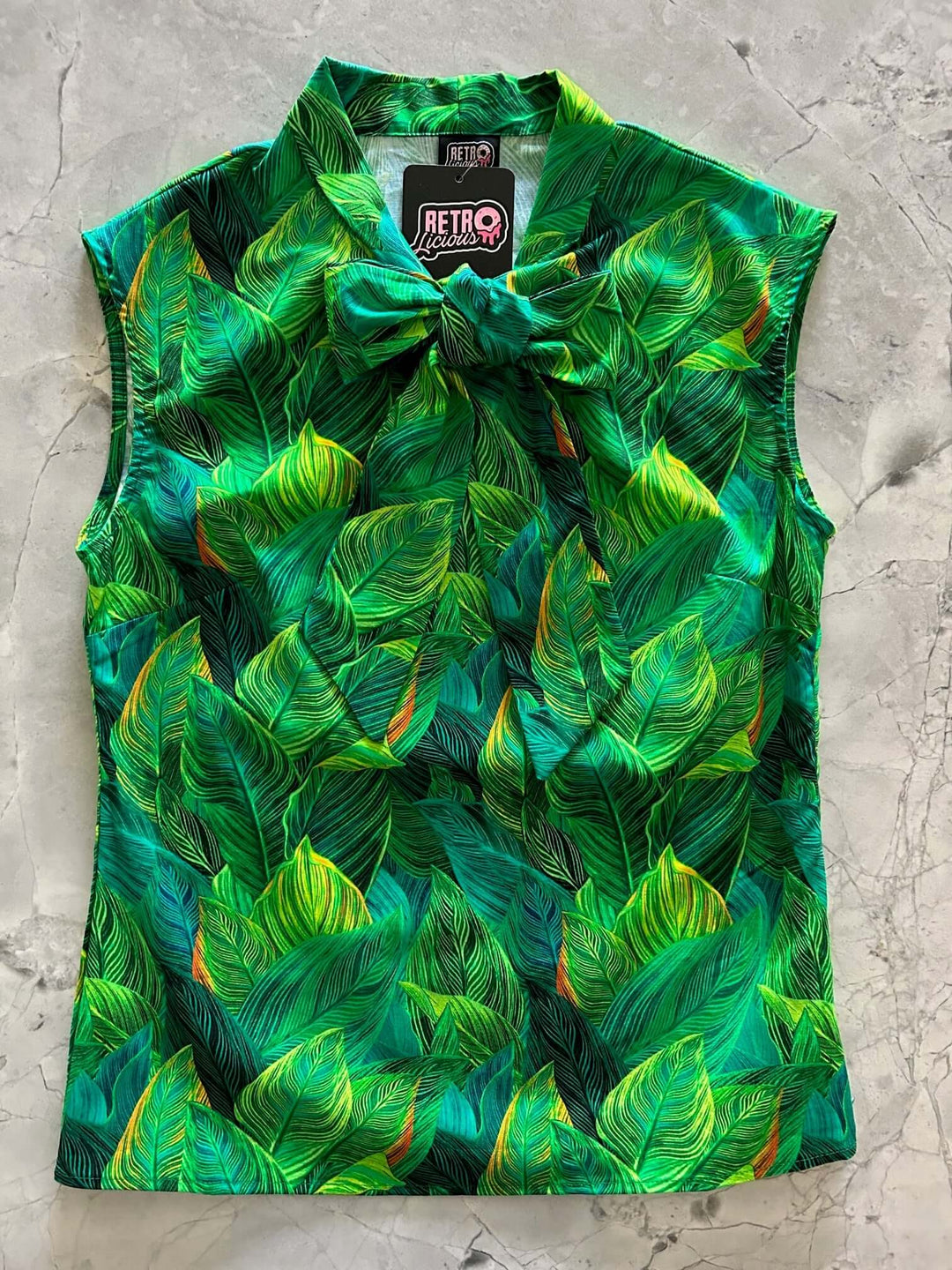 This top is for the vintage lover at heart! Shown in our leaves print, this 100% cotton top features bust darts for a flattering silhouette, a side zippered closure for ease of wear, and an oversized bow at the neckline for that perfect 1950&