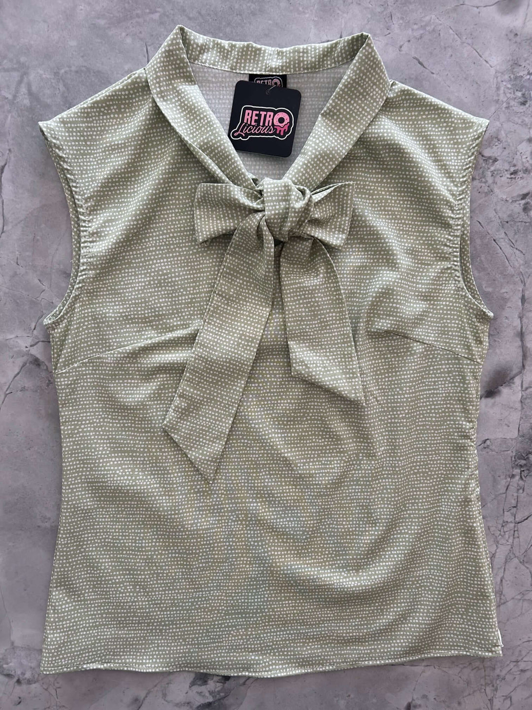 Vintage Style Tops This top is for the vintage lover at heart! Now available in our Sage Dot print. This 100% cotton top features bust darts for a flattering silhouette, a side zippered closure for ease of wear, and an oversized bow at the neckline for that perfect 1950&