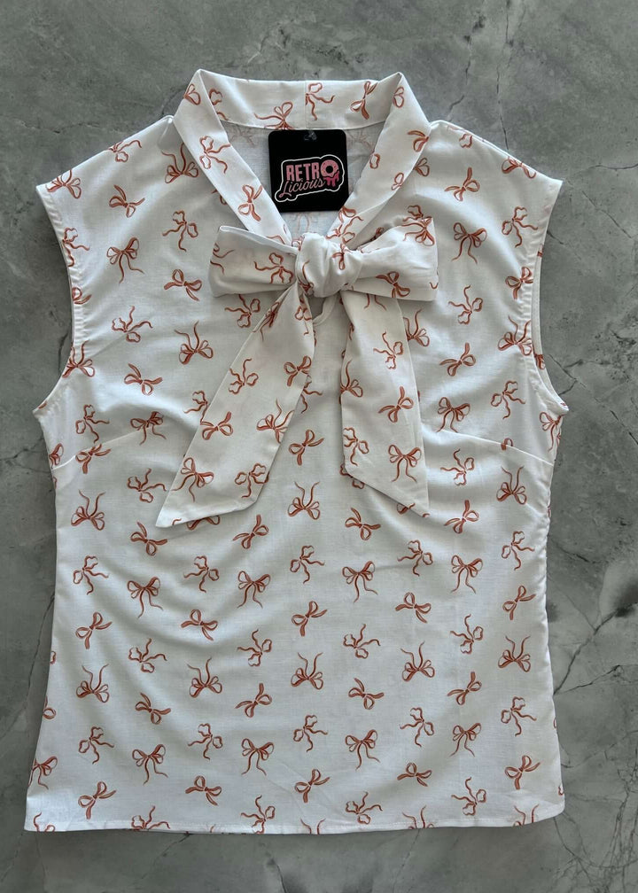 Vintage Style Tops This top is for the vintage lover at heart! Now available in our Pink Bows print. This 100% cotton top features bust darts for a flattering silhouette, a side zippered closure for ease of wear, and an oversized bow at the neckline for that perfect 1950&
