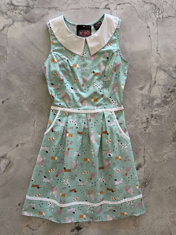 Shop the Dogs Collared Dress by Retrolicious — 60s-style A-line, dog print, Peter Pan collar, pockets, 100% cotton. Made in USA. Sizes XS–4X.