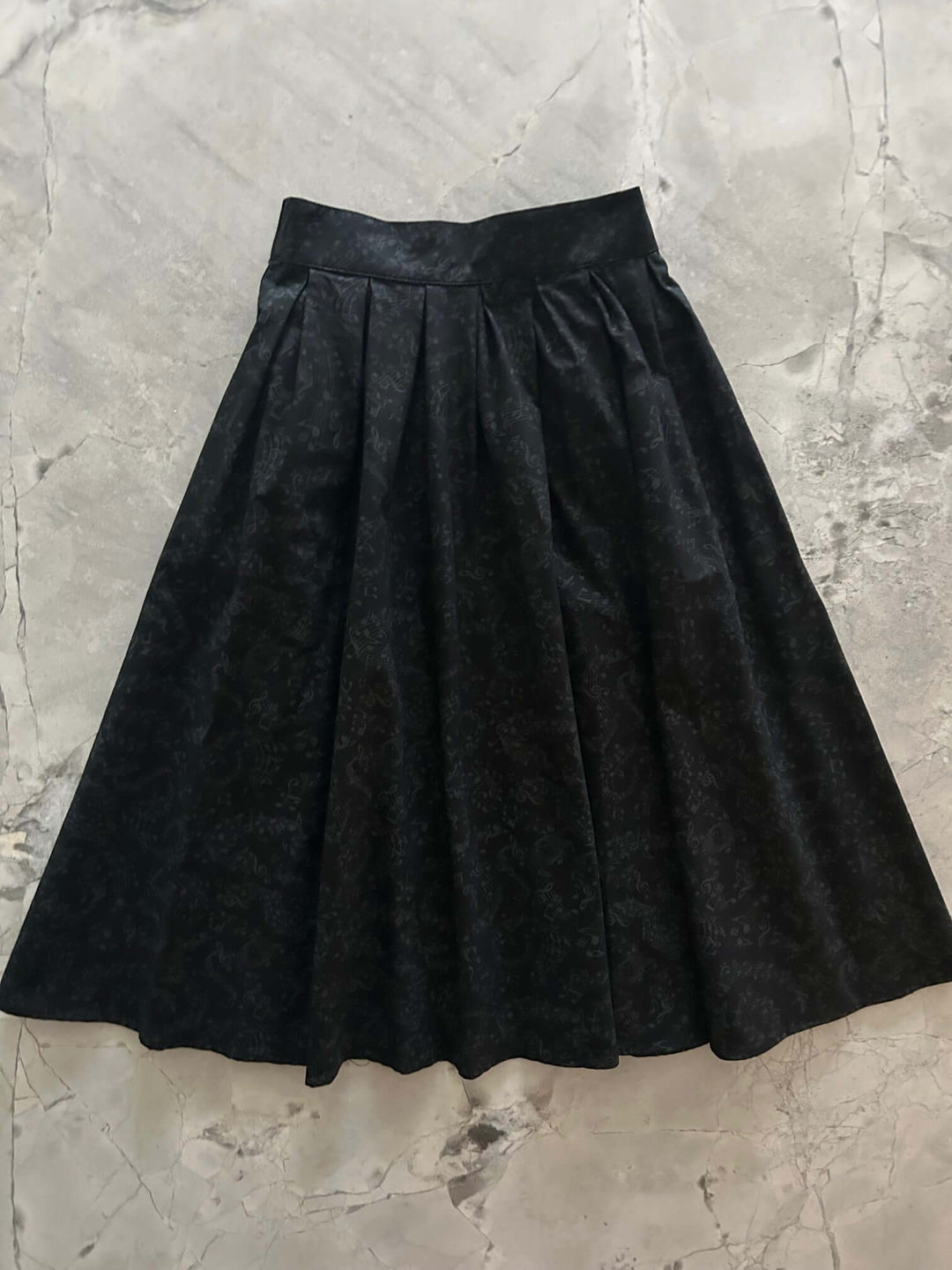 Made in USA. Shop the Music Notes Doris cotton skirt by Retrolicious, with a longer pleated silhouette, pockets and elasticized back waist. 