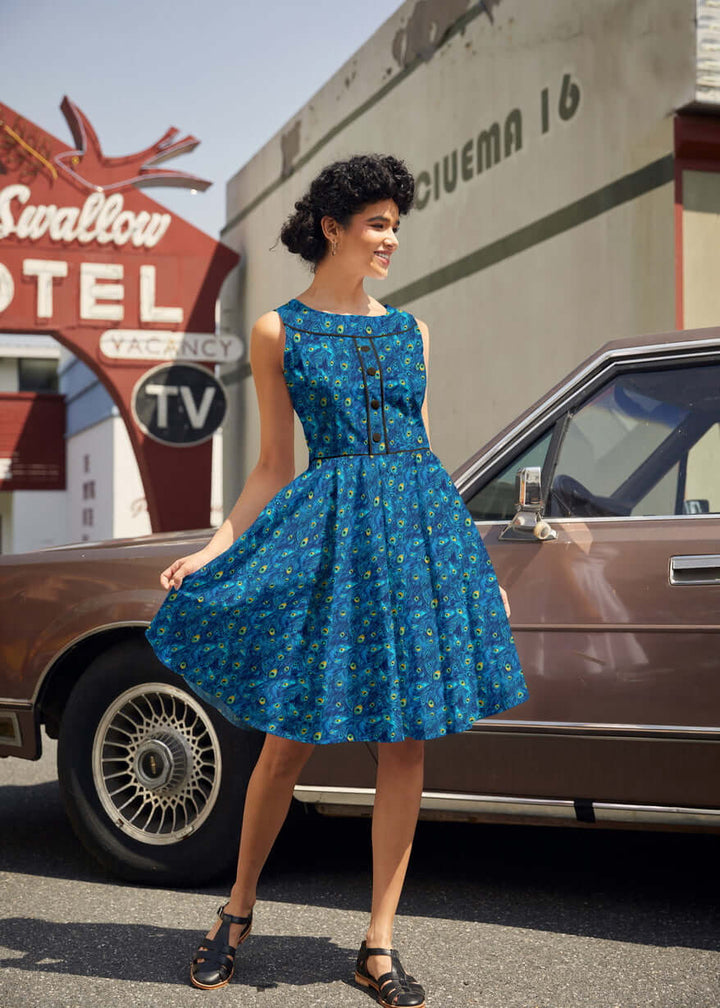 Shop the Elizabeth Dress by Retrolicious — vintage peacock print, piping details, knee length, pockets, 100% cotton. Made in USA. Sizes XS–4X.