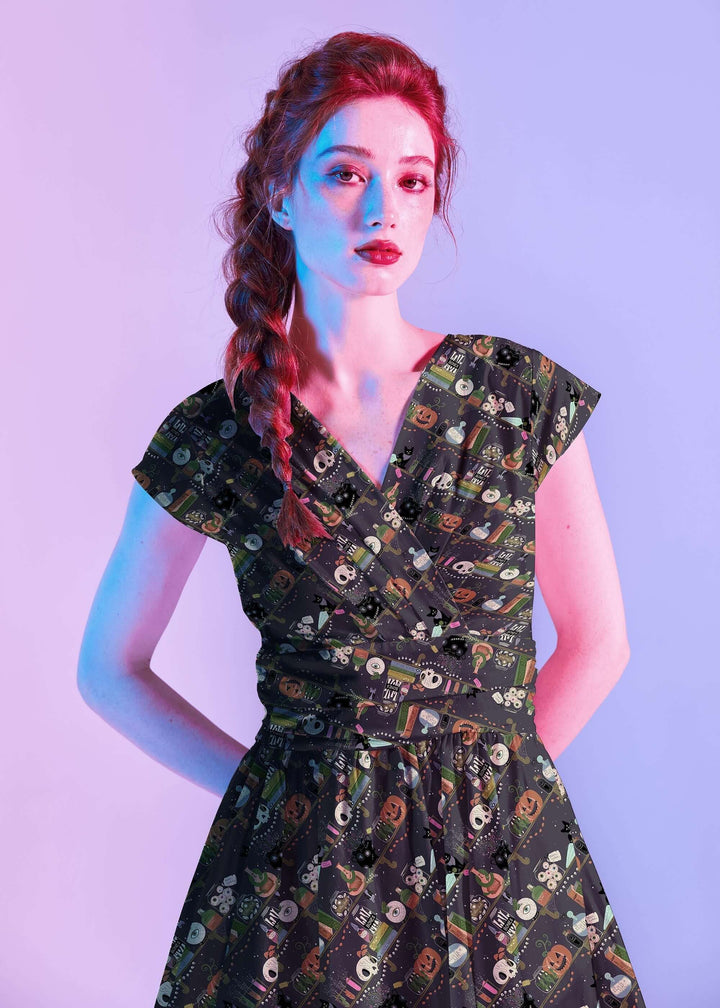 Made in USA, the Retrolicious Potions Greta dress is 100% cotton with a V-neck, gathered waist, pockets, and a true-to-size fit. Sizes XS–4X.