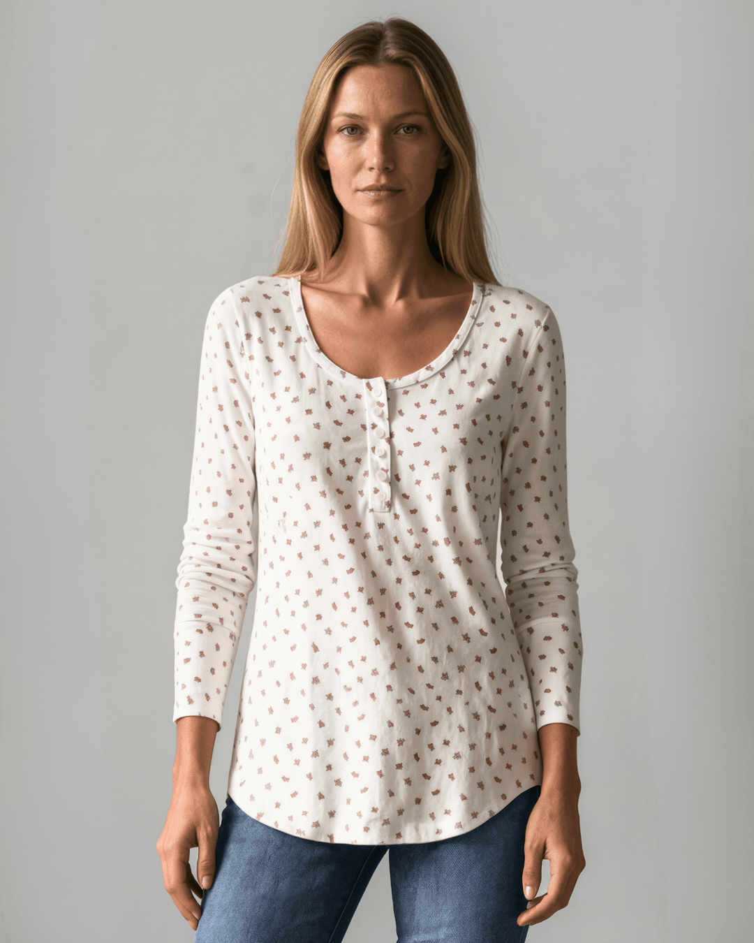 Made in USA. Ivory and red ditsy floral fitted Henley top. Scoop neck, button placket, long sleeves, stretchy knit. 95% polyester. Sizes S–XL.