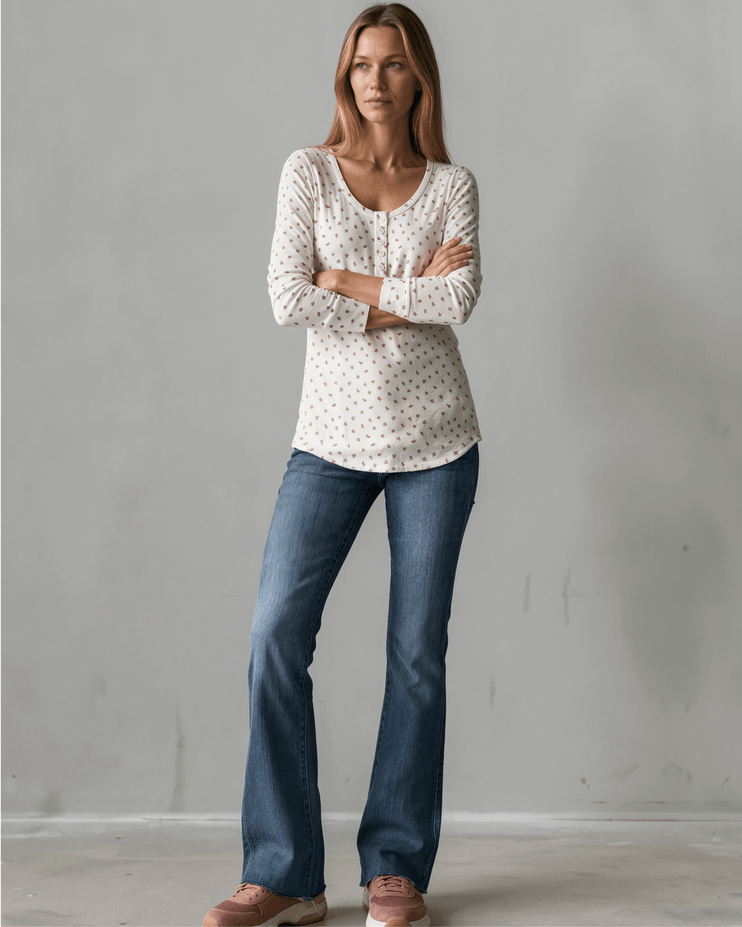 Made in USA. Ivory and red ditsy floral fitted Henley top. Scoop neck, button placket, long sleeves, stretchy knit. 95% polyester. Sizes S–XL.