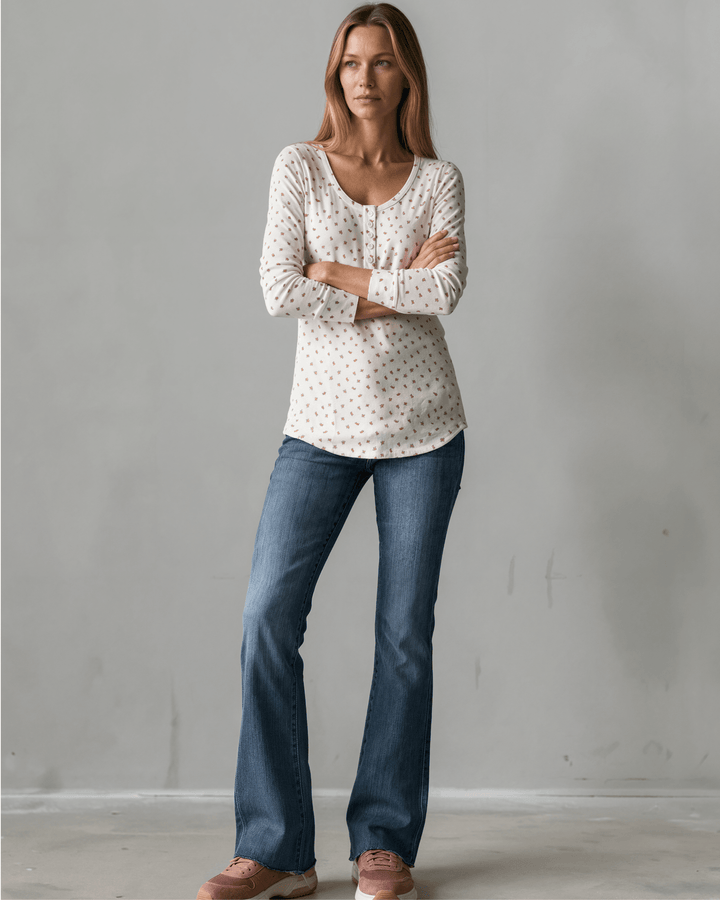 Made in USA. Ivory and red ditsy floral fitted Henley top. Scoop neck, button placket, long sleeves, stretchy knit. 95% polyester. Sizes S–XL.