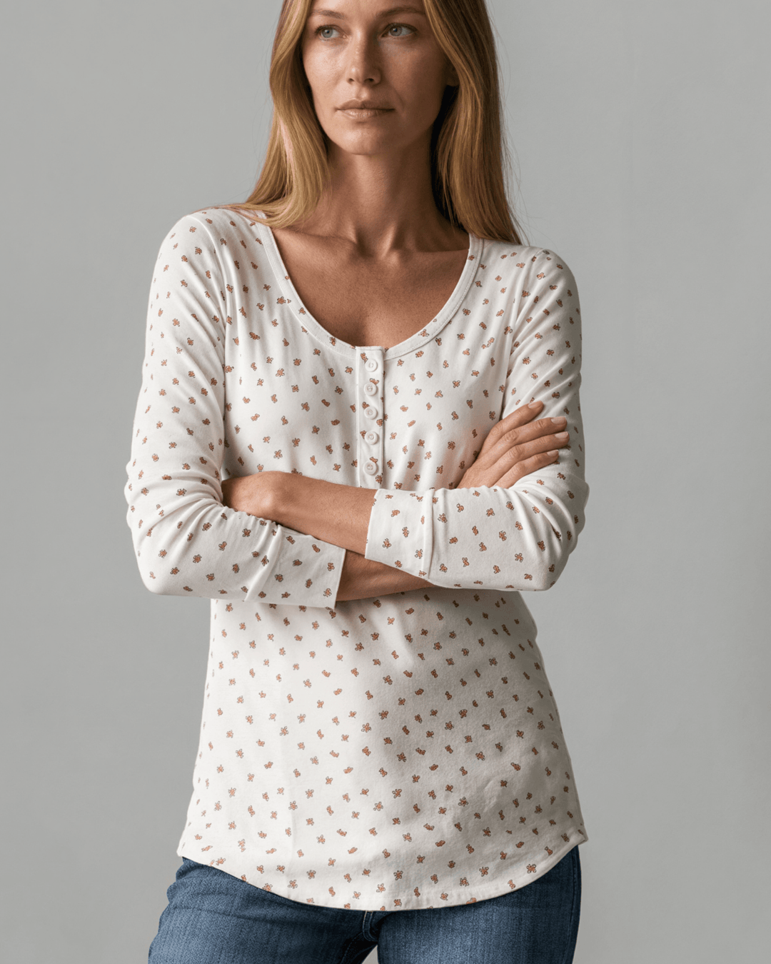 Made in USA. Ivory and red ditsy floral fitted Henley top. Scoop neck, button placket, long sleeves, stretchy knit. 95% polyester. Sizes S–XL.