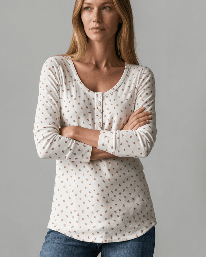 Made in USA. Ivory and red ditsy floral fitted Henley top. Scoop neck, button placket, long sleeves, stretchy knit. 95% polyester. Sizes S–XL.