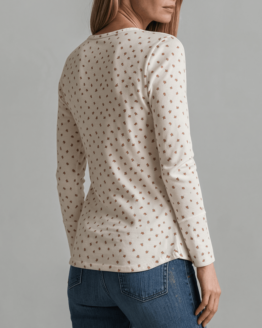 Made in USA. Ivory and red ditsy floral fitted Henley top. Scoop neck, button placket, long sleeves, stretchy knit. 95% polyester. Sizes S–XL.