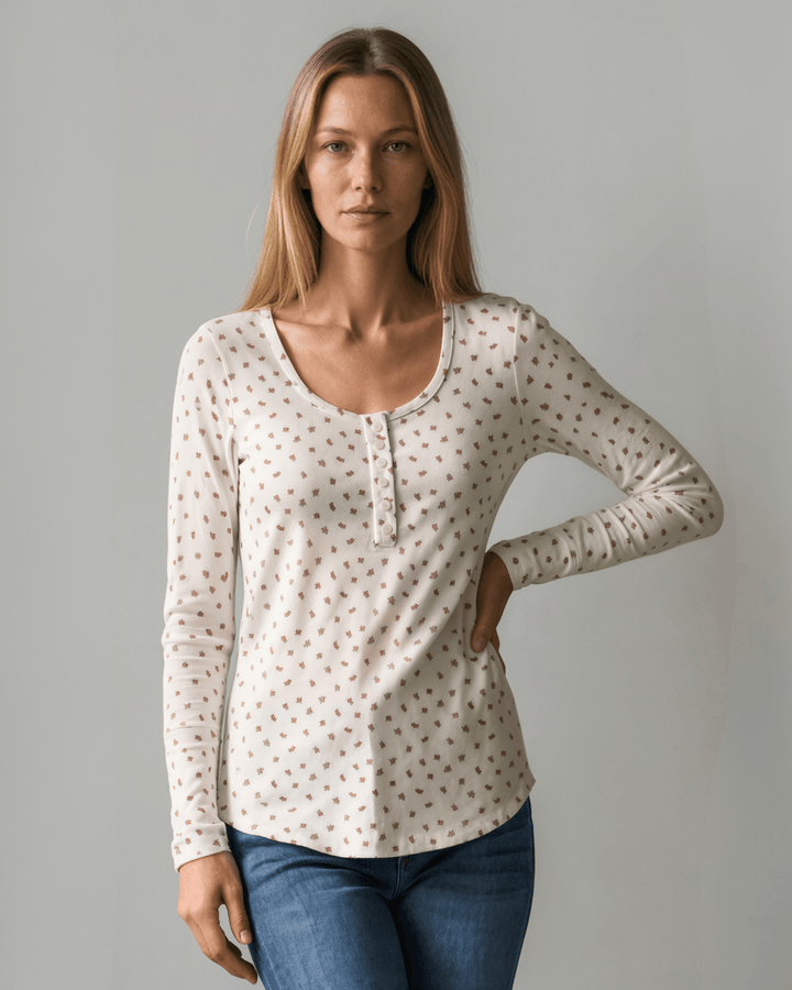 Made in USA. Ivory and red ditsy floral fitted Henley top. Scoop neck, button placket, long sleeves, stretchy knit. 95% polyester. Sizes S–XL.