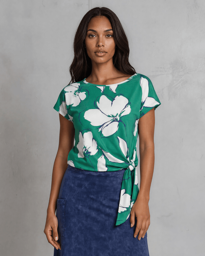 Shop the Farrah Floral Knot Top in bold green &amp; white. Semi-fitted, side knot detail, cap sleeves, sizes S-L. 95% Poly/5% Spandex. Made in USA.