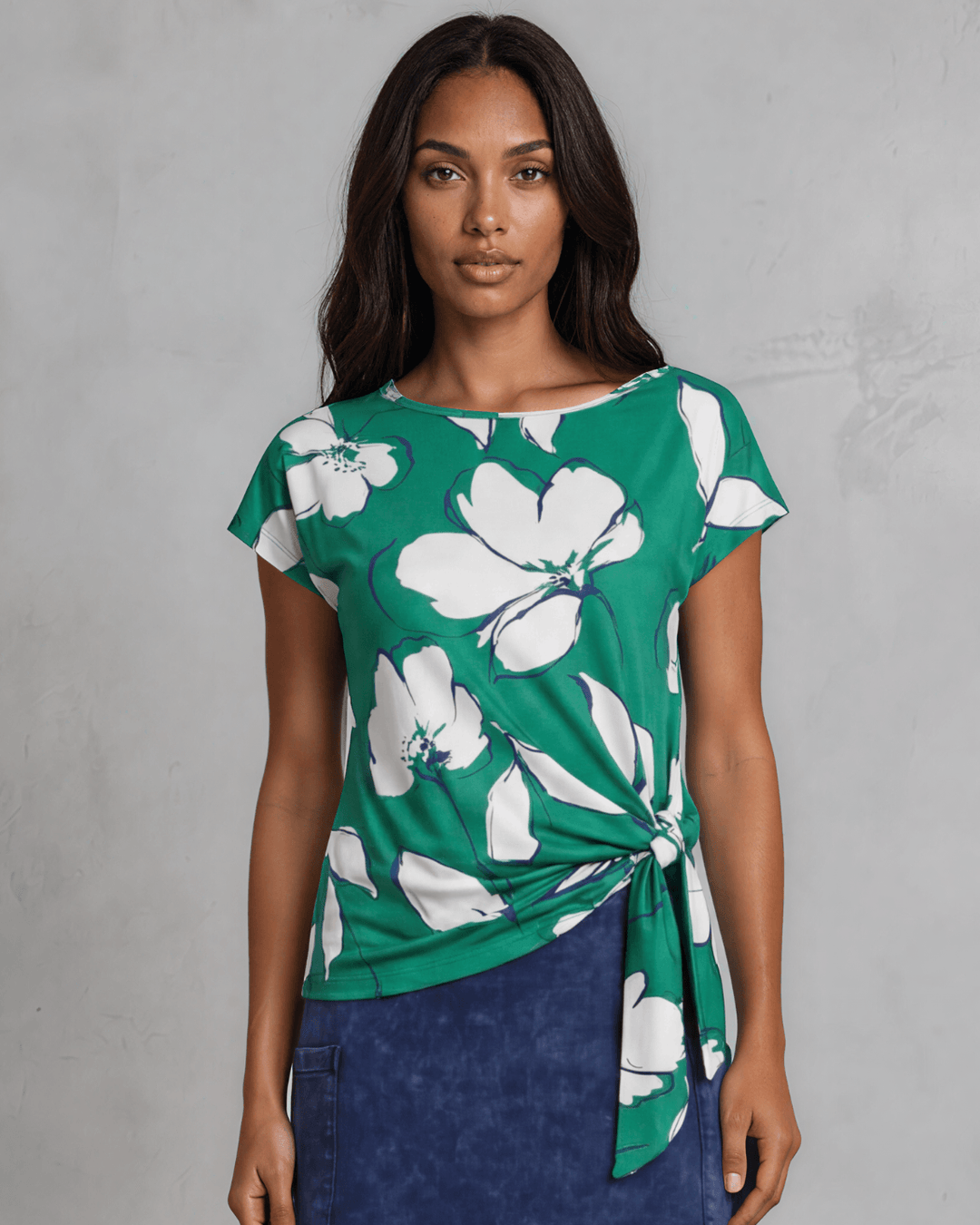 Shop the Farrah Floral Knot Top in bold green & white. Semi-fitted, side knot detail, cap sleeves, sizes S-L. 95% Poly/5% Spandex. Made in USA.
