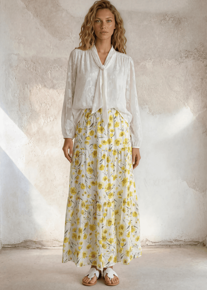 Sunshine meets style — the Sara Sunflower Bloom Maxi Skirt features a yellow floral print, three flowy tiers, and an elastic waist. Made in USA.