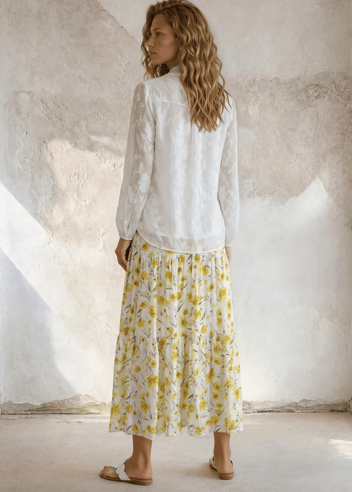 Sunshine meets style — the Sara Sunflower Bloom Maxi Skirt features a yellow floral print, three flowy tiers, and an elastic waist. Made in USA.