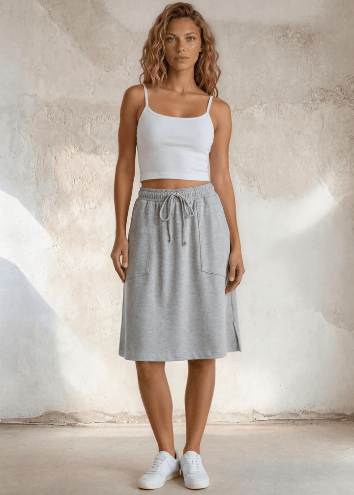 Pockets, stretch, and effortless style — the Penelope Knee Length Pocket Skirt in Heather Gray is your new warm-weather staple. Made in USA.