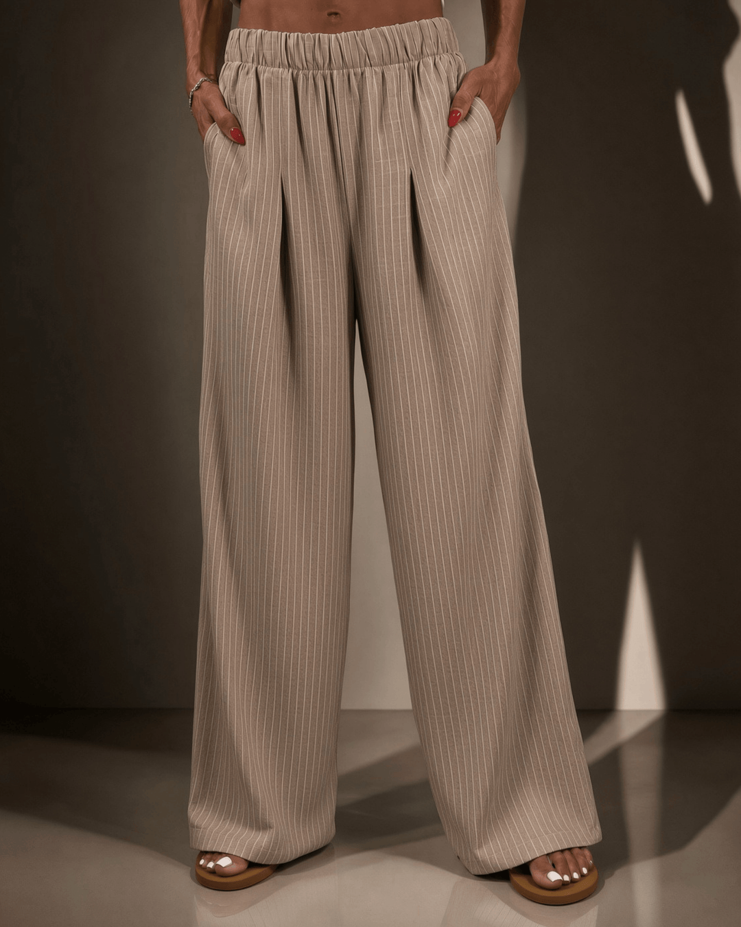Made in USA Avery Women's high-rise wide leg pinstripe pant in taupe. Elastic waist, pleated front, full length. 85% rayon, 15% linen. Sizes S–L.