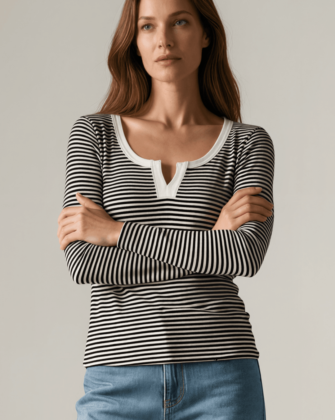 Made in USA. Black & white striped fitted rib knit top. Split V-neck with contrast trim, long sleeves. 97% rayon. Sizes S–XL.