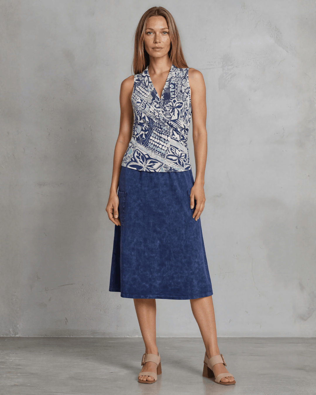Shop the Karol Knit Surplice V-Neck Sleeveless Top in navy tribal print. Fitted, ruched front, sizes S-L. 95% Poly/5% Spandex. Made in USA.