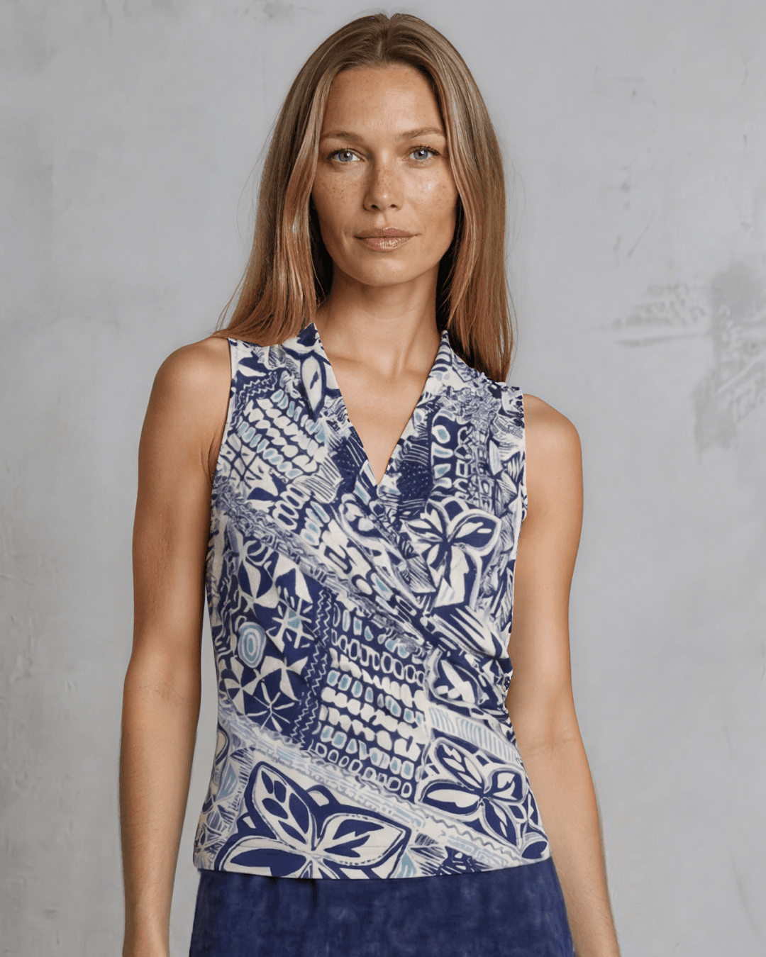 Shop the Karol Knit Surplice V-Neck Sleeveless Top in navy tribal print. Fitted, ruched front, sizes S-L. 95% Poly/5% Spandex. Made in USA.