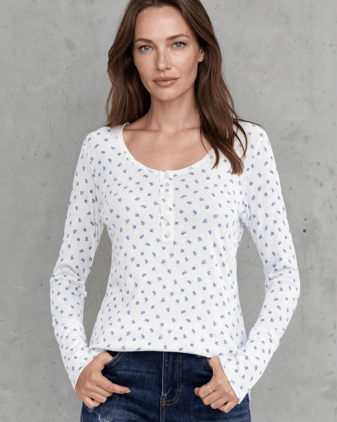 Made in USA. Women's Ivory & blue ditsy floral fitted Henley top. Scoop neck, button placket, long sleeves, stretchy knit. 95% polyester. Sizes S–XL.