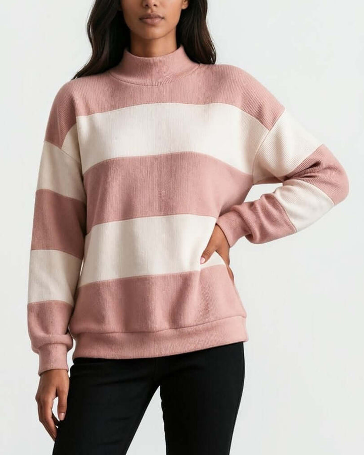A woman wearing 
Made in USA pink and cream striped mock neck sweater with a relaxed fit, soft stretch knit fabric, long sleeves, and ribbed trim.