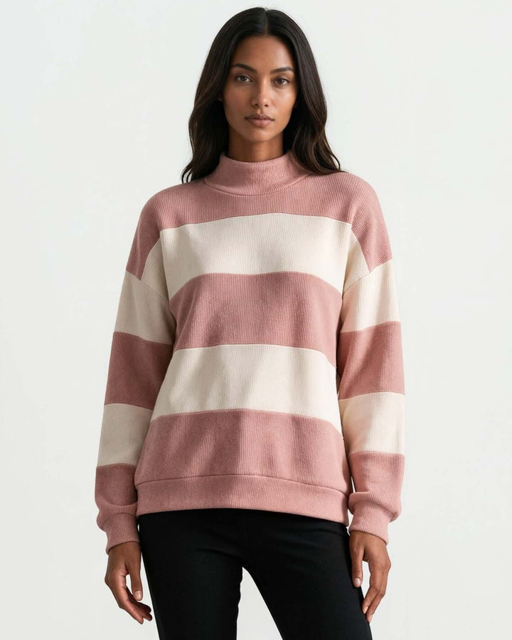 A woman wearing 
Made in USA pink and cream striped mock neck sweater with a relaxed fit, soft stretch knit fabric, long sleeves, and ribbed trim.