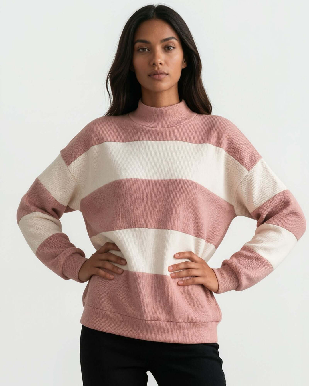 A woman wearing 
Made in USA pink and cream striped mock neck sweater with a relaxed fit, soft stretch knit fabric, long sleeves, and ribbed trim.