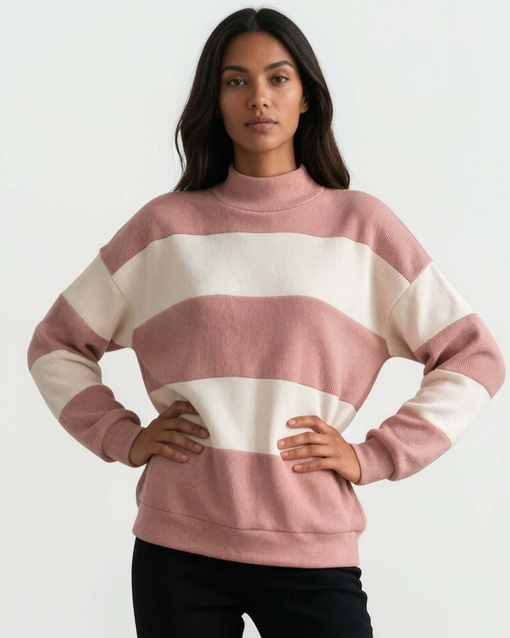 A woman wearing 
Made in USA pink and cream striped mock neck sweater with a relaxed fit, soft stretch knit fabric, long sleeves, and ribbed trim.