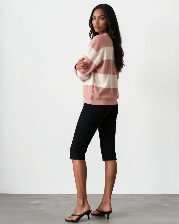 A woman wearing 
Made in USA pink and cream striped mock neck sweater with a relaxed fit, soft stretch knit fabric, long sleeves, and ribbed trim.