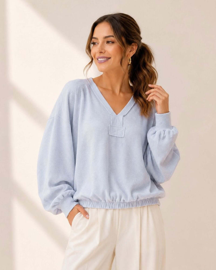 Light blue grey textured knit pullover with bubble sleeves, raw edge V-neck &amp; elastic waist hem. 60% poly 40% cotton. Made in USA. Sizes S–L.