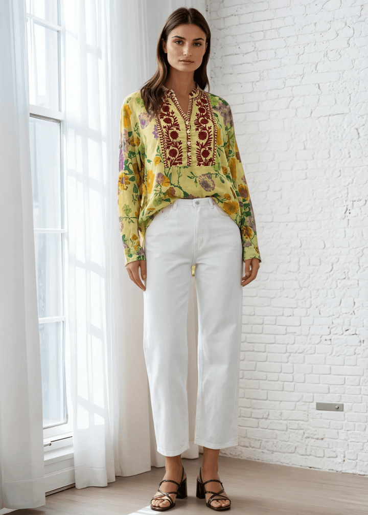 Bask in the beauty of effortless bohemian charm with the Carla Top. Crafted from soft, breathable cotton voile, this piece features a vibrant floral print in sun-kissed tones of golden marigold, lilac, and fresh green. The hand-embroidered deep red bib adds an artisanal touch, making each blouse unique. Designed with a relaxed silhouette and a flattering V-neckline, it&
