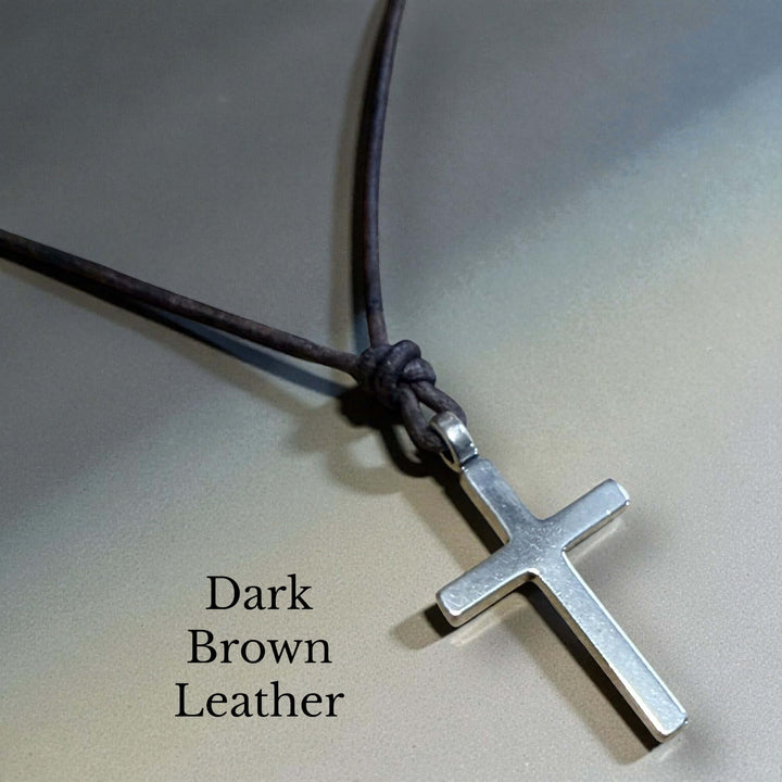 Handcrafted solid sterling silver cross on an adjustable leather cord. Unisex. Available in black, dark brown, or red brown. Made in USA