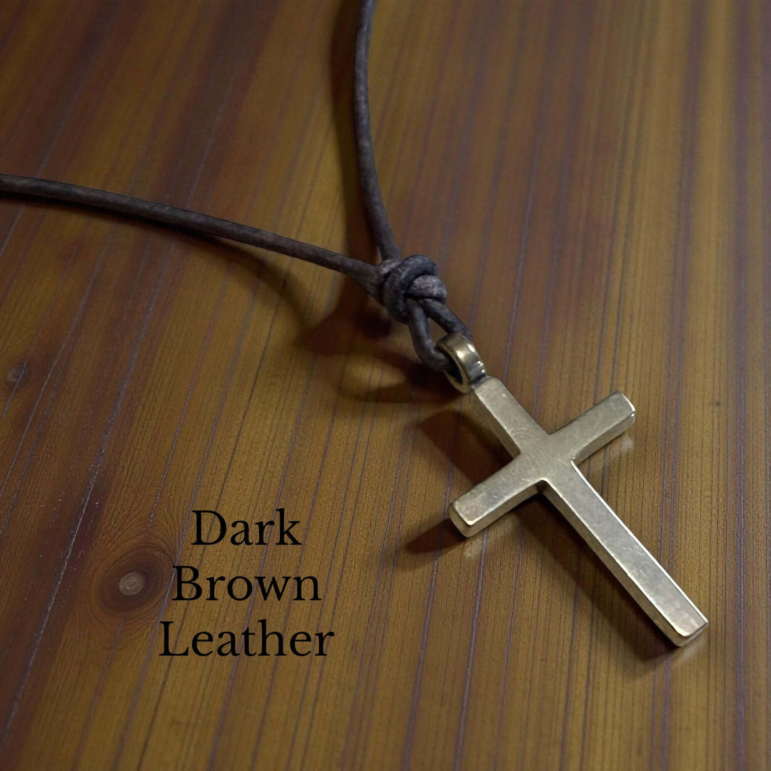 Handcrafted solid bronze cross on an adjustable leather cord. Unisex, red brown or dark brown. Made in USA with a lifetime warranty