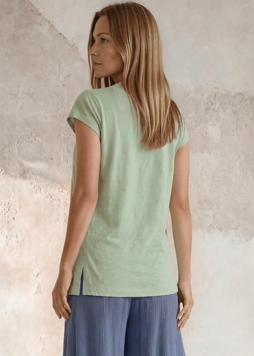Shop the Meghan Tee — a garment-dyed, fitted scoop neck tee in Neil Green with a Denim Blue Flower Graphic. 50% cotton / 50% modal, ultra-soft. Made in USA.