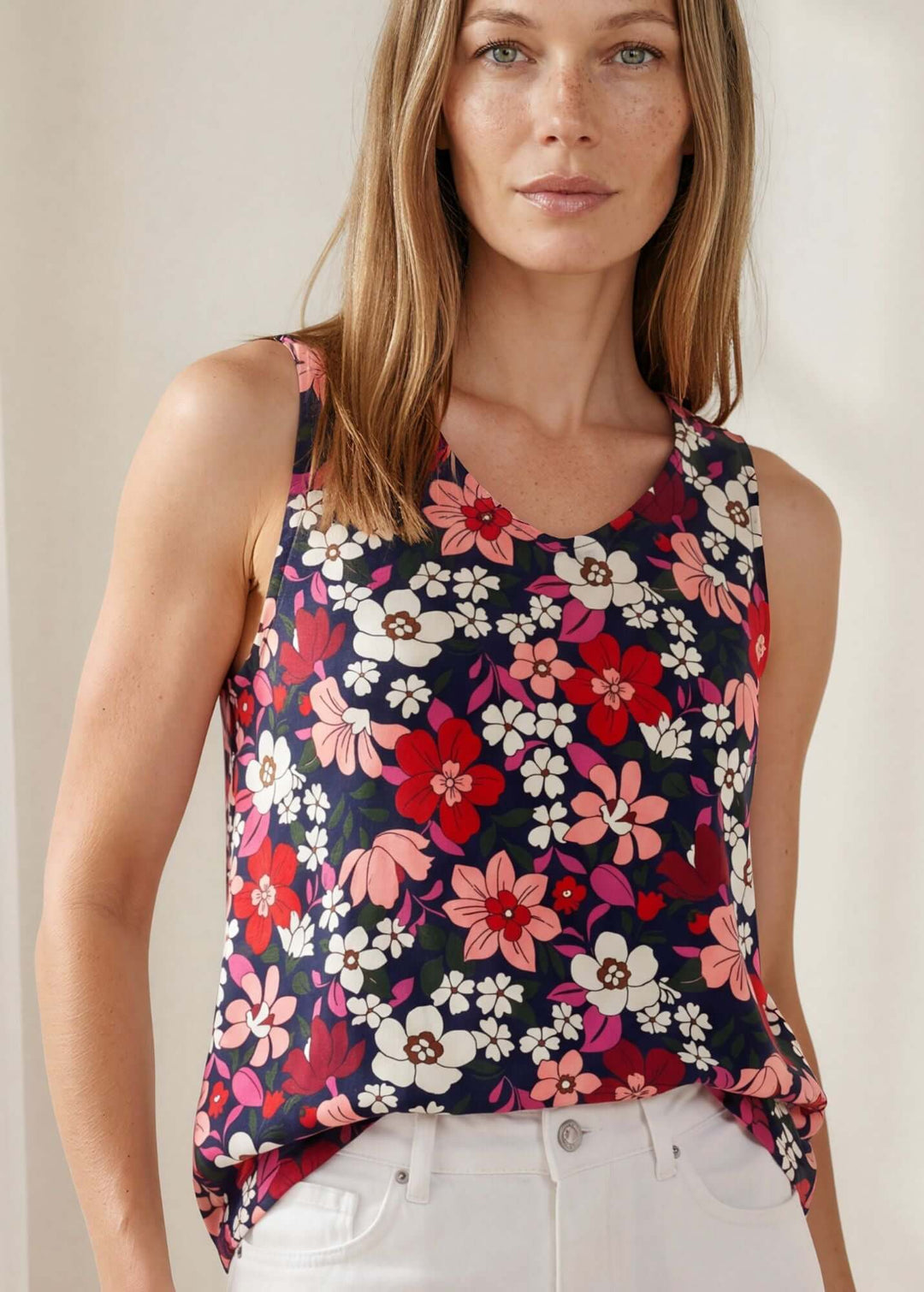  Vivi Vibrant Floral V-Neck Top — a bold navy floral sleeveless top in 95% polyester. Relaxed fit, feminine V-neck. Made in USA.