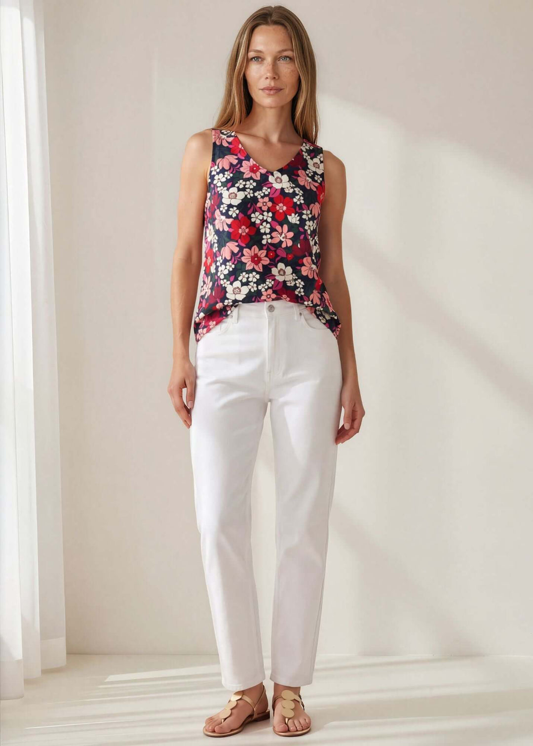  Vivi Vibrant Floral V-Neck Top — a bold navy floral sleeveless top in 95% polyester. Relaxed fit, feminine V-neck. Made in USA.